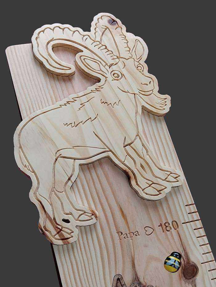 Partie du haut d’une toise sur le thème de la montagne, un bouquetin sculpté, un edelweiss en liège et une petite abeille.