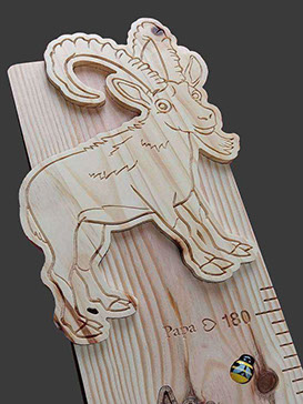 Partie du haut d’une toise sur le thème de la montagne, un bouquetin sculpté, un edelweiss en liège et une petite abeille.