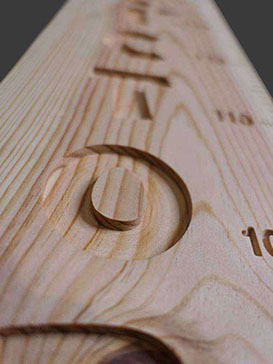 Jolie vue en perspective du prénom sculpté tout le long de la toise en bois, les veines soulignent la beauté des caractères.