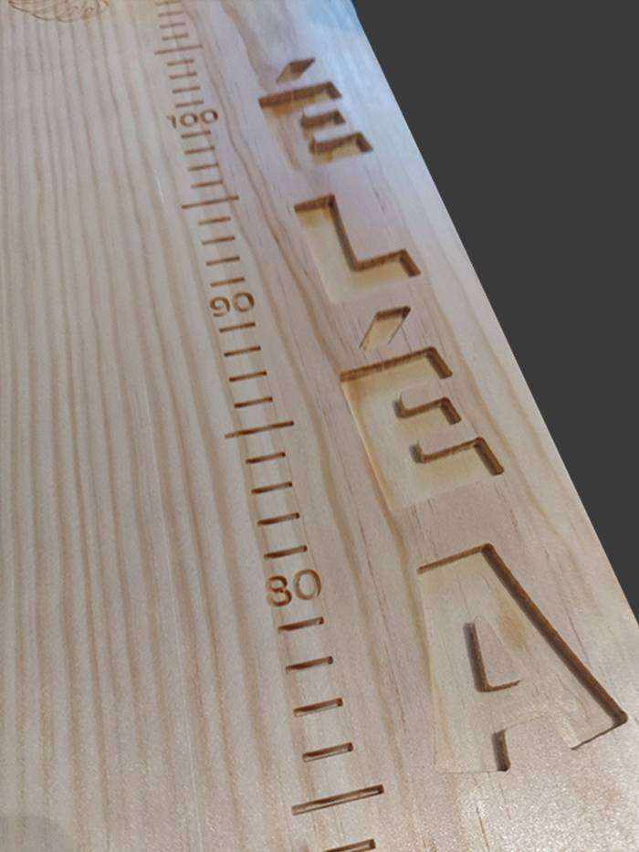 Toise en bois pour deux sœurs. Graduations centrales, avec les prénoms sculptés sur les côtés à différentes hauteurs.