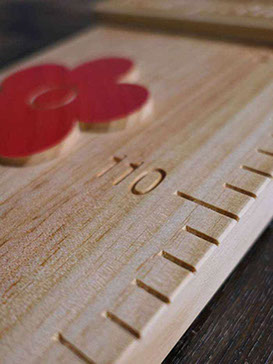 Cette photo de toise en bois montre que les décors ne sont pas simplement collés mais encastrés précisément dans la toise.