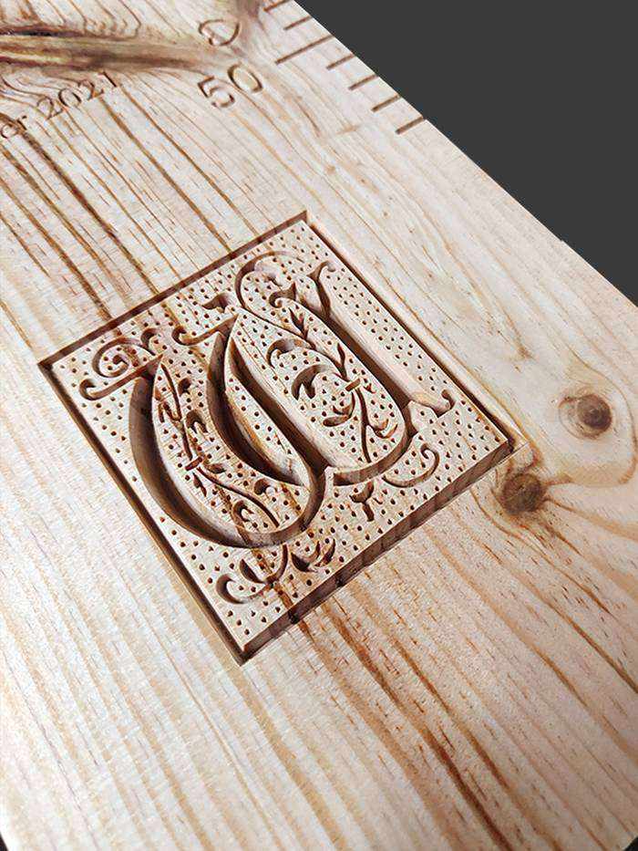 Une lettrine sculptée dans une toise s'amuse avec les veines du bois. La toise trône à présent dans le salon des parents.