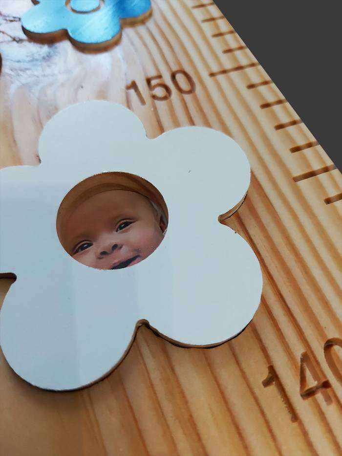 Sur cette toise, une fleur amovible accueille la photo de l'enfant. La photo peut être facilement remplacée quand il grandit.