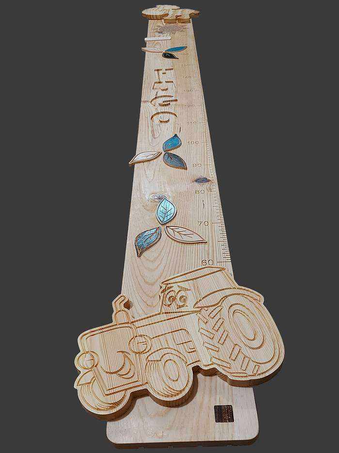 Jolie toise en bois sur le thème de la ferme, vache sculptée en haut, un tracteur en bas et le prénom Hugo sculpté au centre