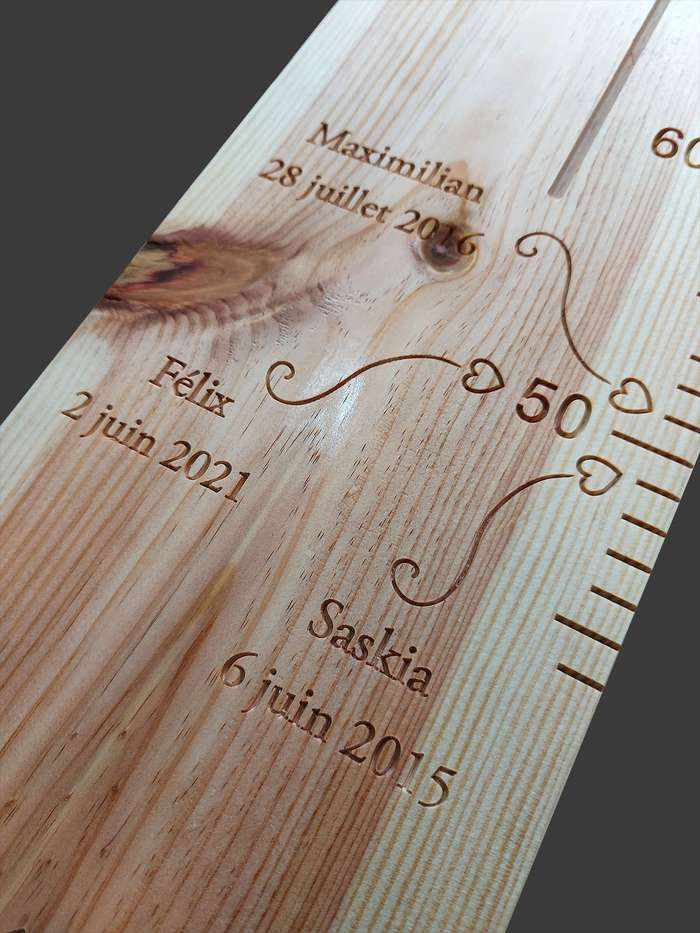 Les prénoms et dates de naissance des enfants sur cette toise en bois. De jolies flèches sculptées à la taille de naissance.