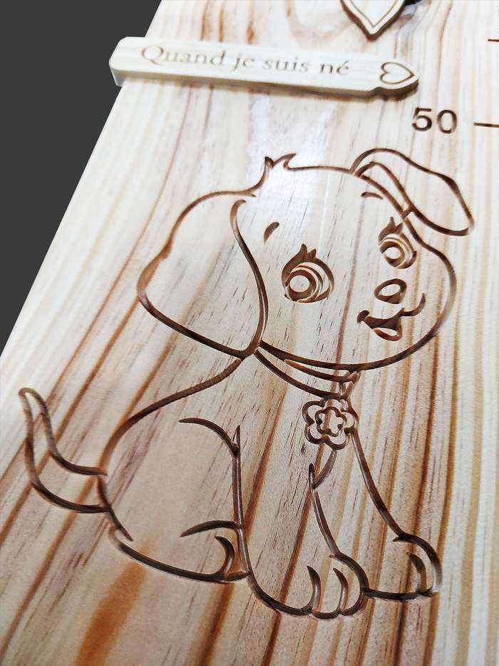 Sur la toise en bois, ce petit chien semble sourire à l'enfant. Comme les souvenirs, le décor sculpté ne s'effacera pas.