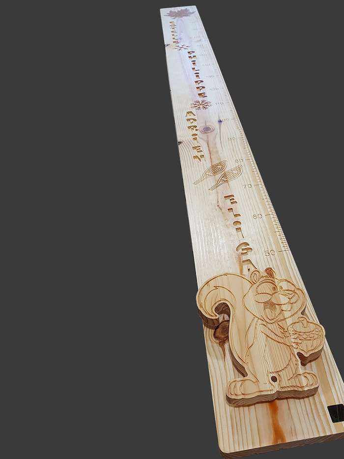 Toise canadienne en bois avec feuille d'érable, écureuil et les prénoms de quatre enfants,oeuvre personnalisée et familiale.