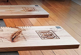 Deux toises en bois massif personnalisées pour des sœurs. Des lettrines celtes, graduations sculptées, et superbes veines naturelles.