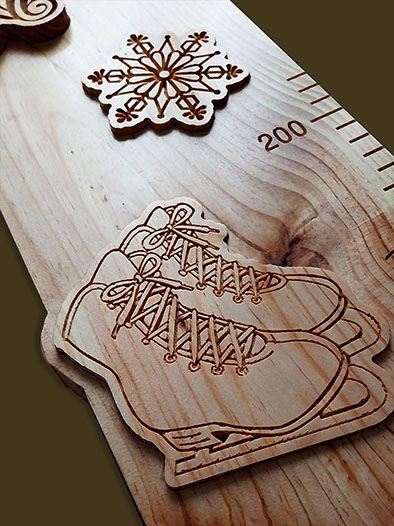 Détail des patins à glace et étoile de neige sculptés dans la toise en bois, symboles du patinage artistique.