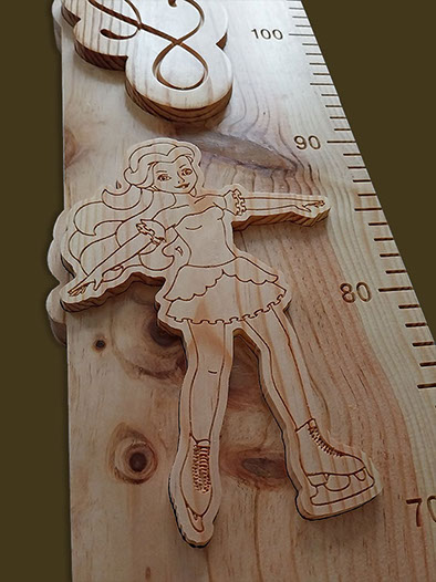 Détail d'une patineuse artistique sculptée dans la toise en bois, figée dans un moment gracieux de son mouvement.